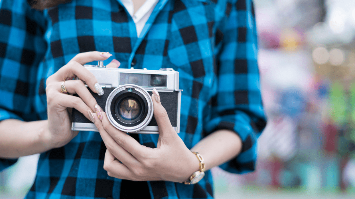 A woman holding a film camera.