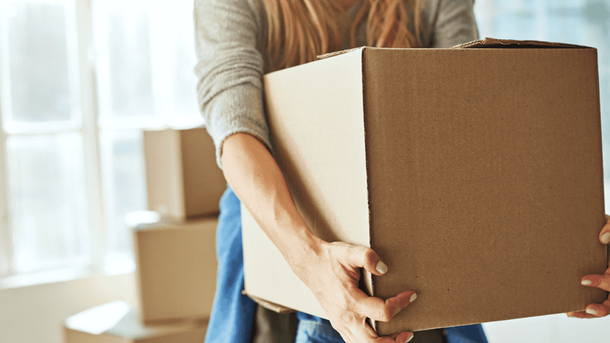 A woman holding a moving box.