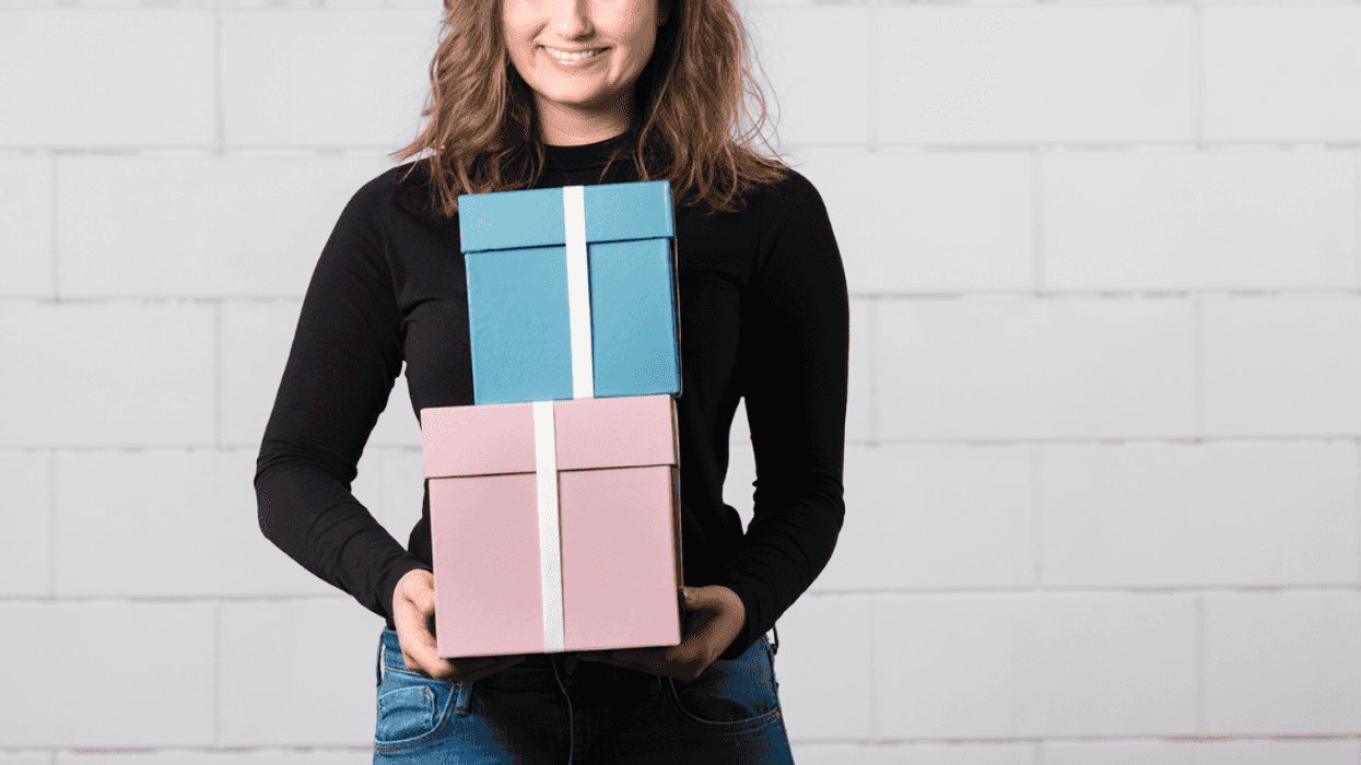 A woman holding a pink and blue box.