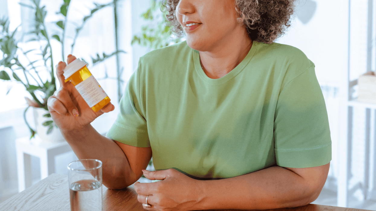 A woman holding a prescription bottle.