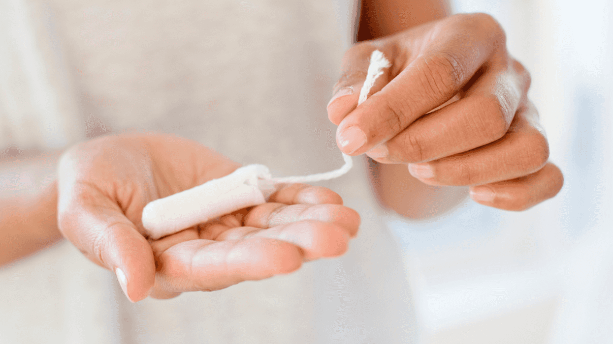 A woman holding a tampon in her hands.