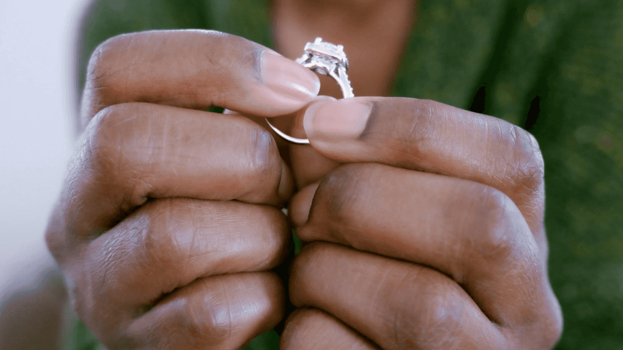 A woman holding an engagement ring.