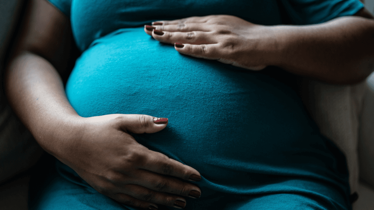 A woman holding her pregnant belly.