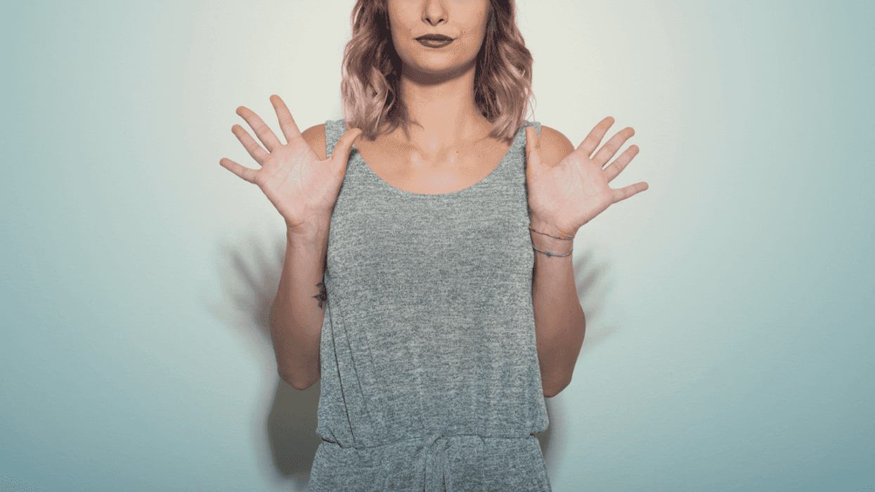 A woman holding our her palms saying no.