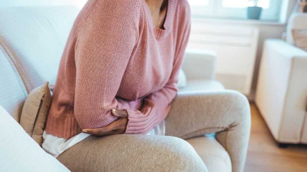 A woman holds her stomach in pain