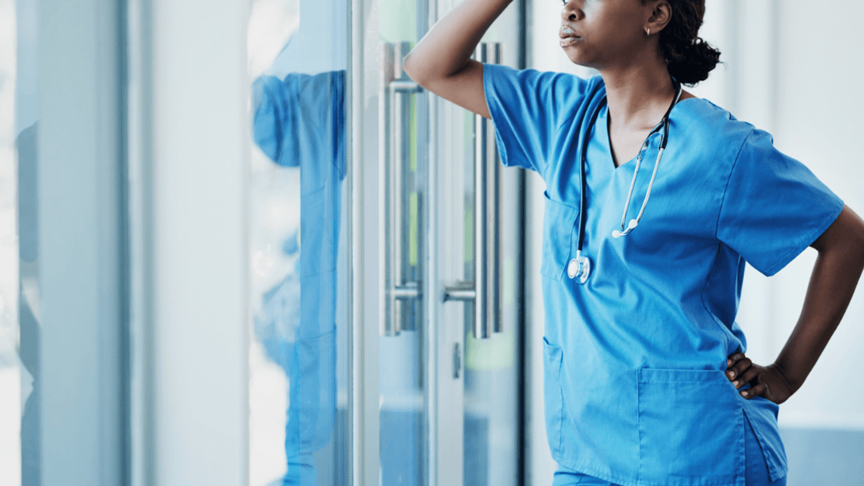 A woman in a nurse's uniform looking distressed.
