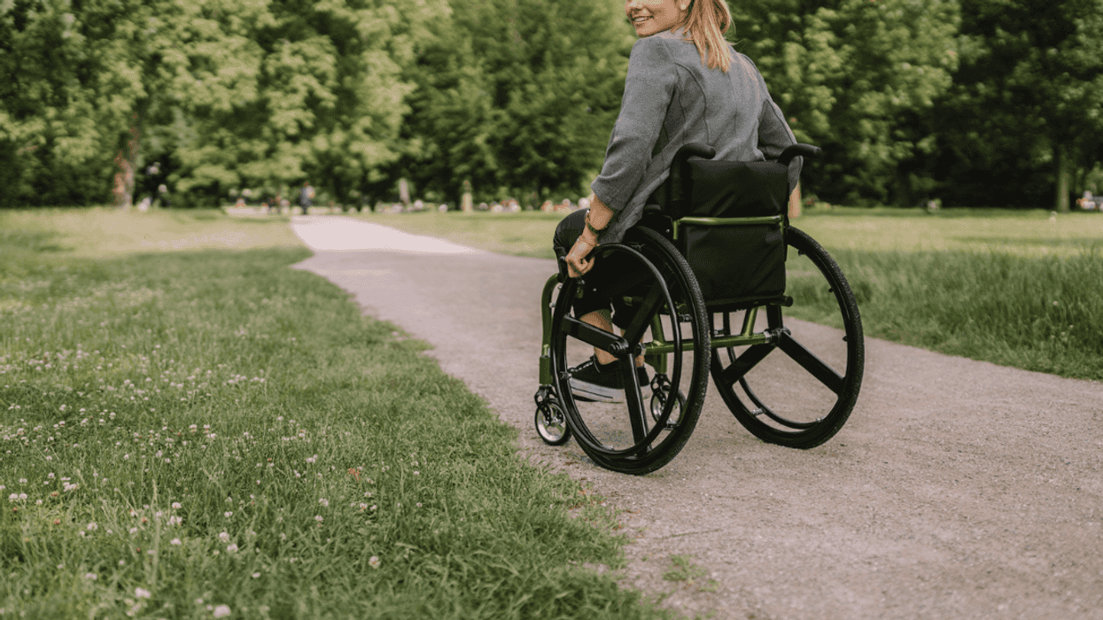 A woman in a wheelchair on the road.