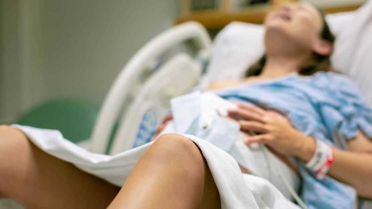 A woman in labor, with painful contractions, lying in the hospital bed. Childbirth and baby delivery.