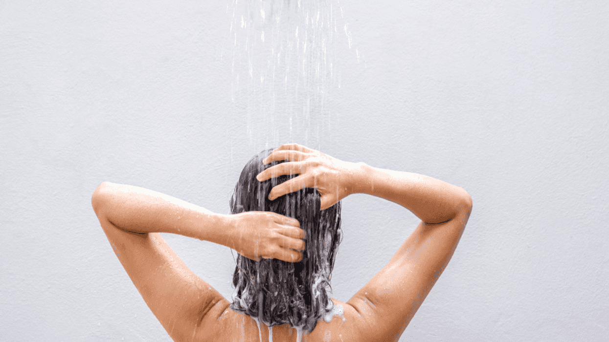 A woman in the shower washing her hair.