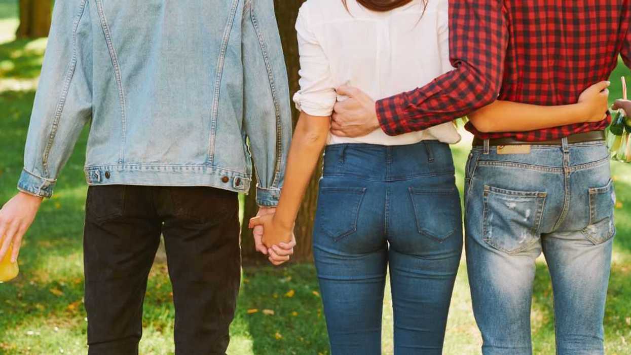 A woman is held by two men on either side of her