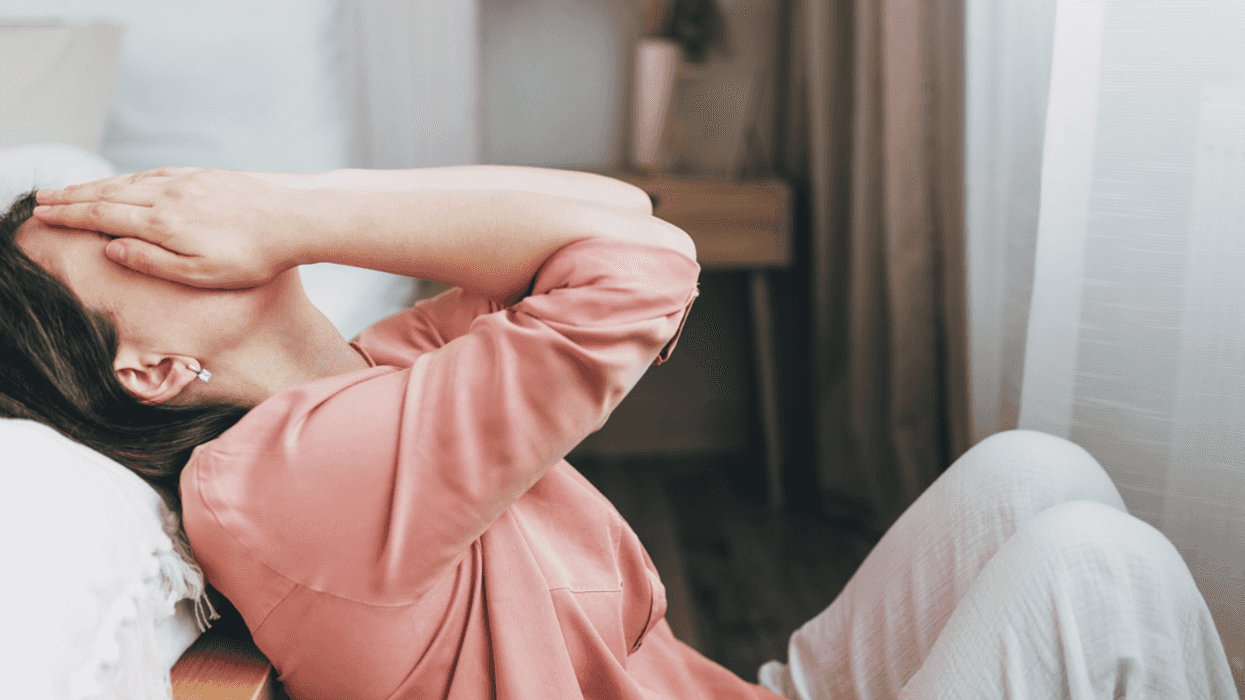 A woman laying back with her hand in her hand.