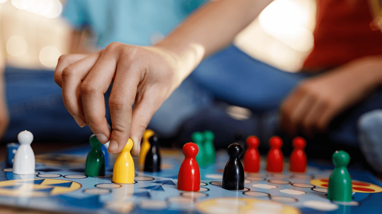A woman moving a figure on a board game