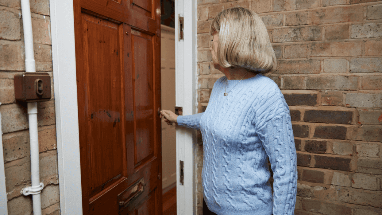 A woman opening a front door.