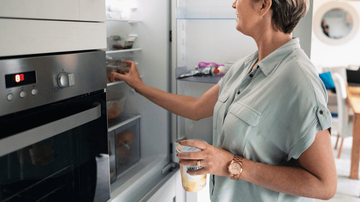 A woman picking through items in the fridge