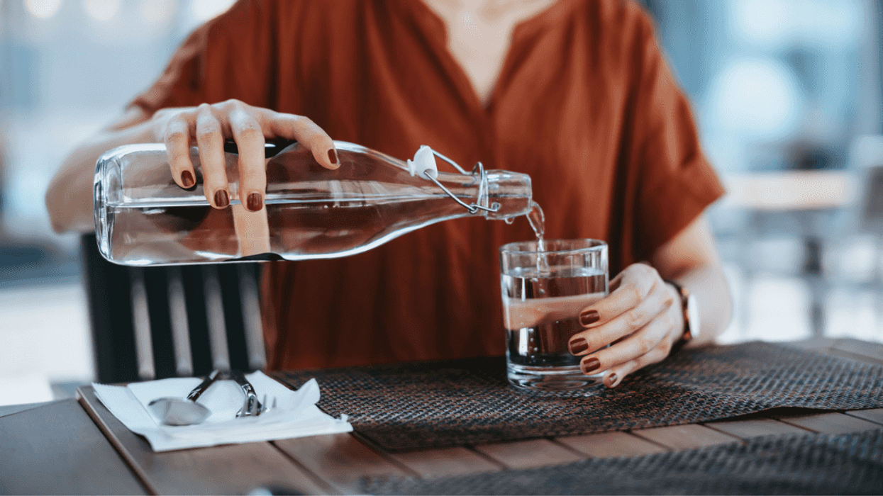 A woman pouring a glass of water.