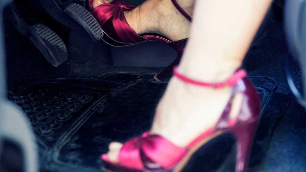 A woman's feet in fancy heels pushing car pedals