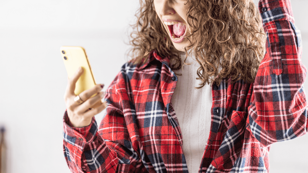 A woman screaming into her cell phone.