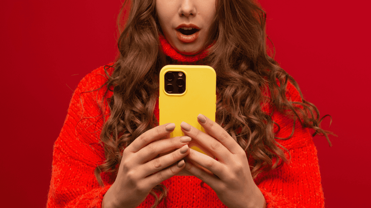 A woman shocked while looking at her phone
