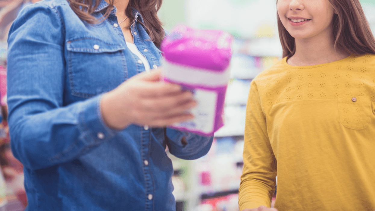 A woman showing a young woman period products