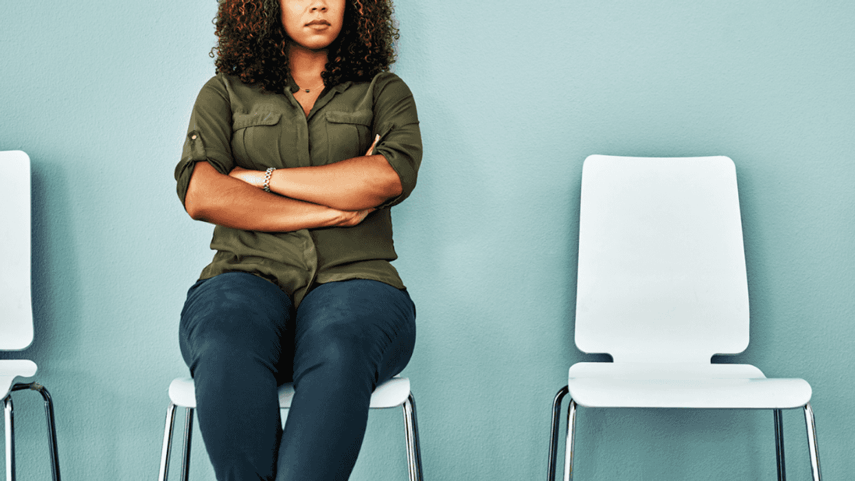 A woman sitting in a chair with her arms folded.