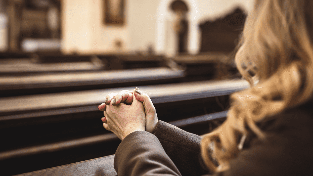 A woman sitting in a church pew.