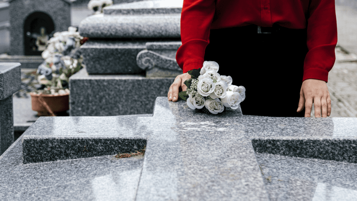 A woman standing at a grave.