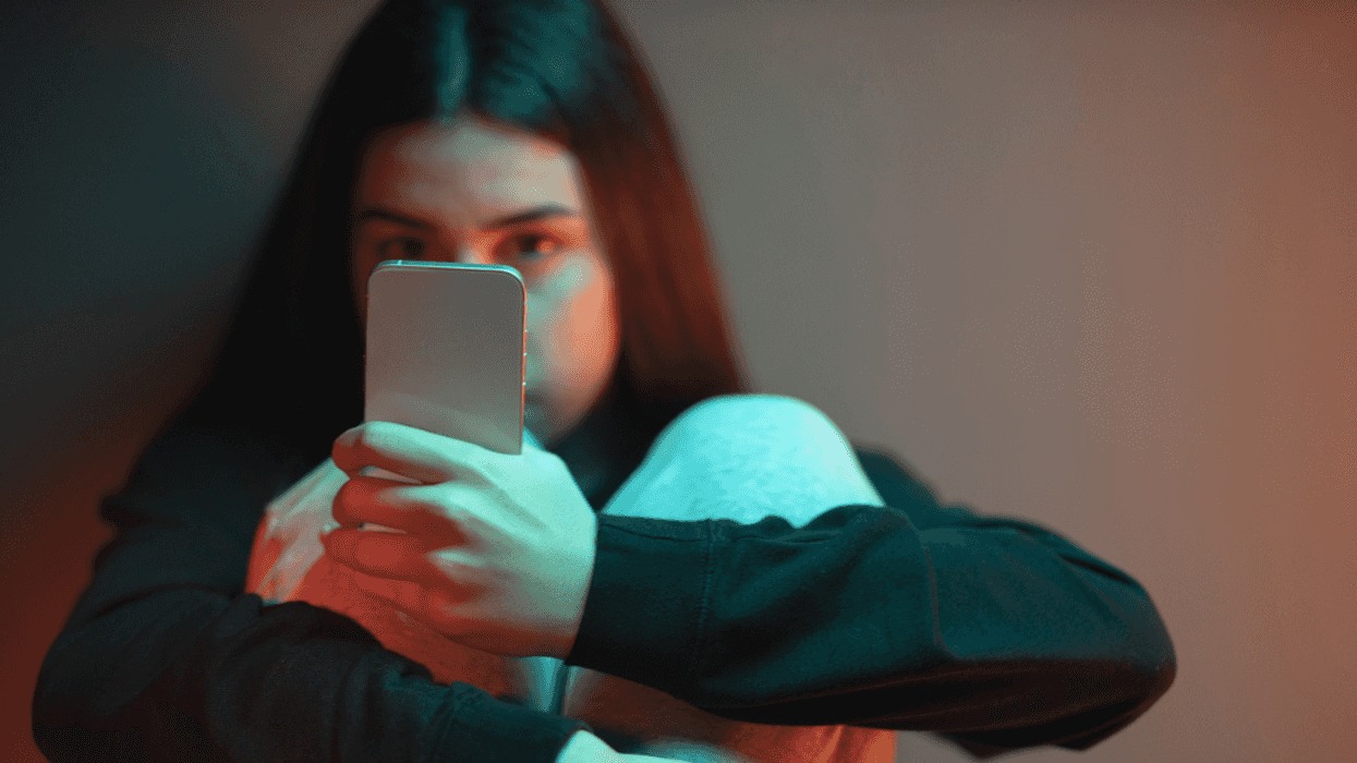 A woman staring intently at her phone.