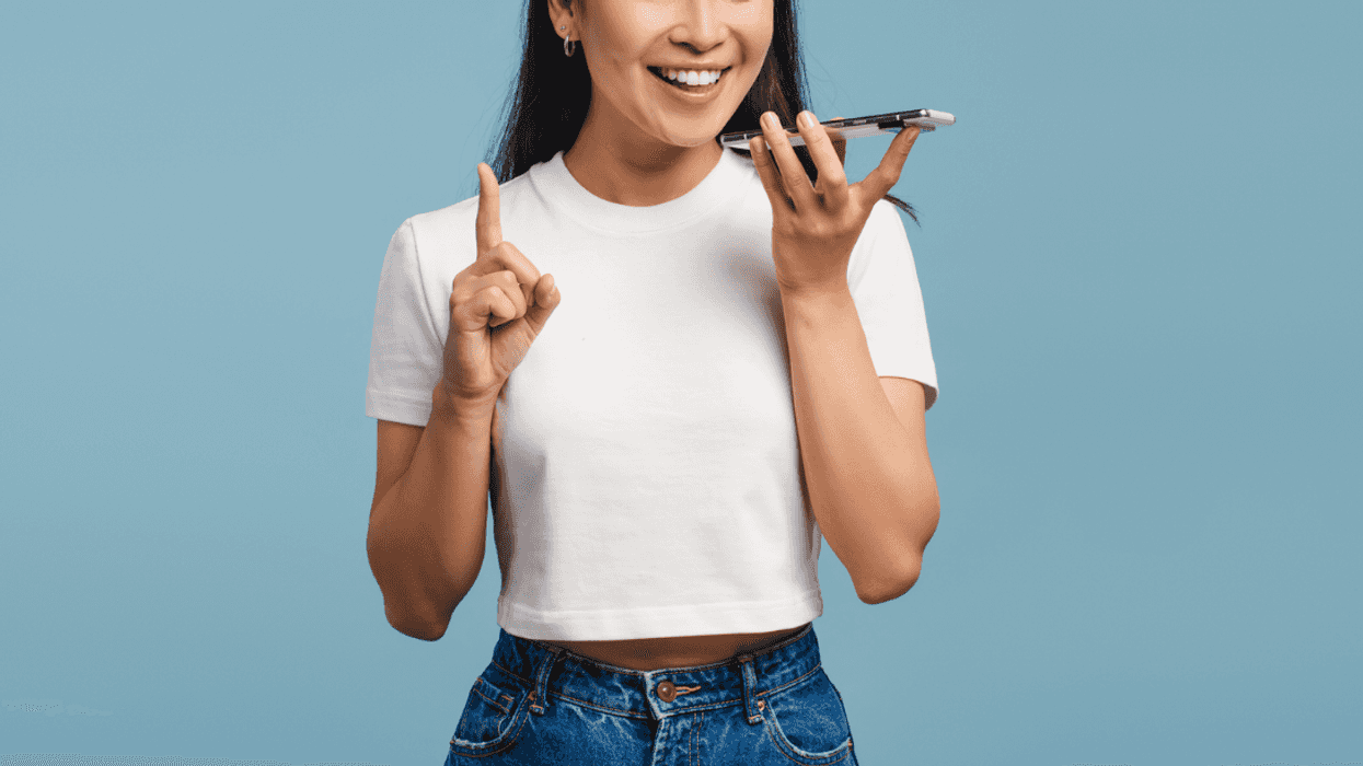 A woman talking into a cell phone on speakerphone.