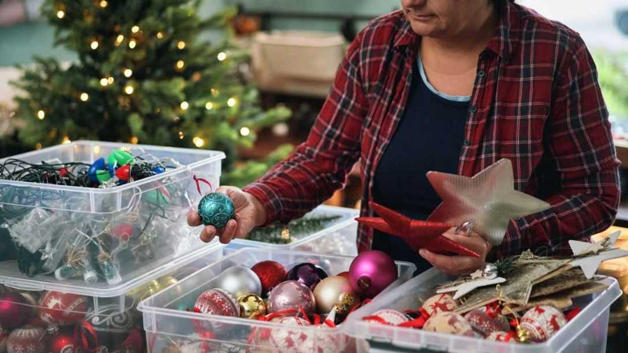 A woman unpacks Christmas decorations.
