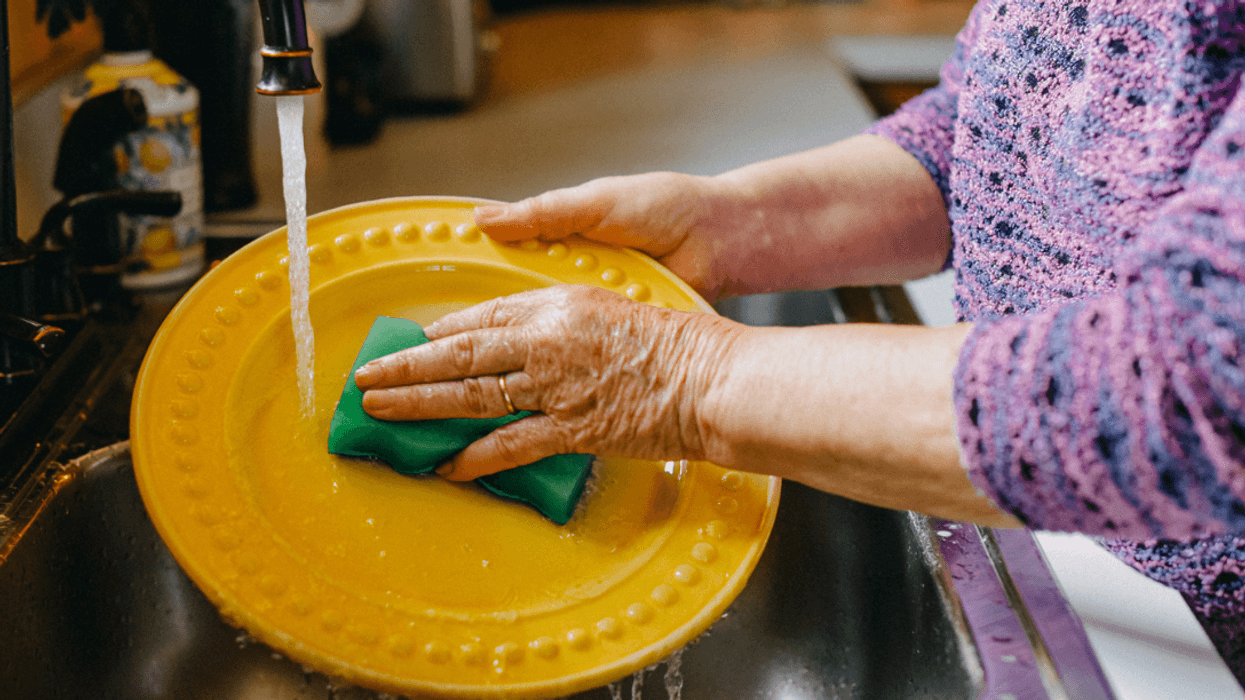 A woman washing a dish in the sink.