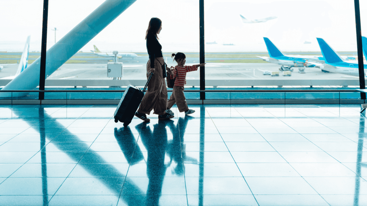 A woman with a child walking through the airport.
