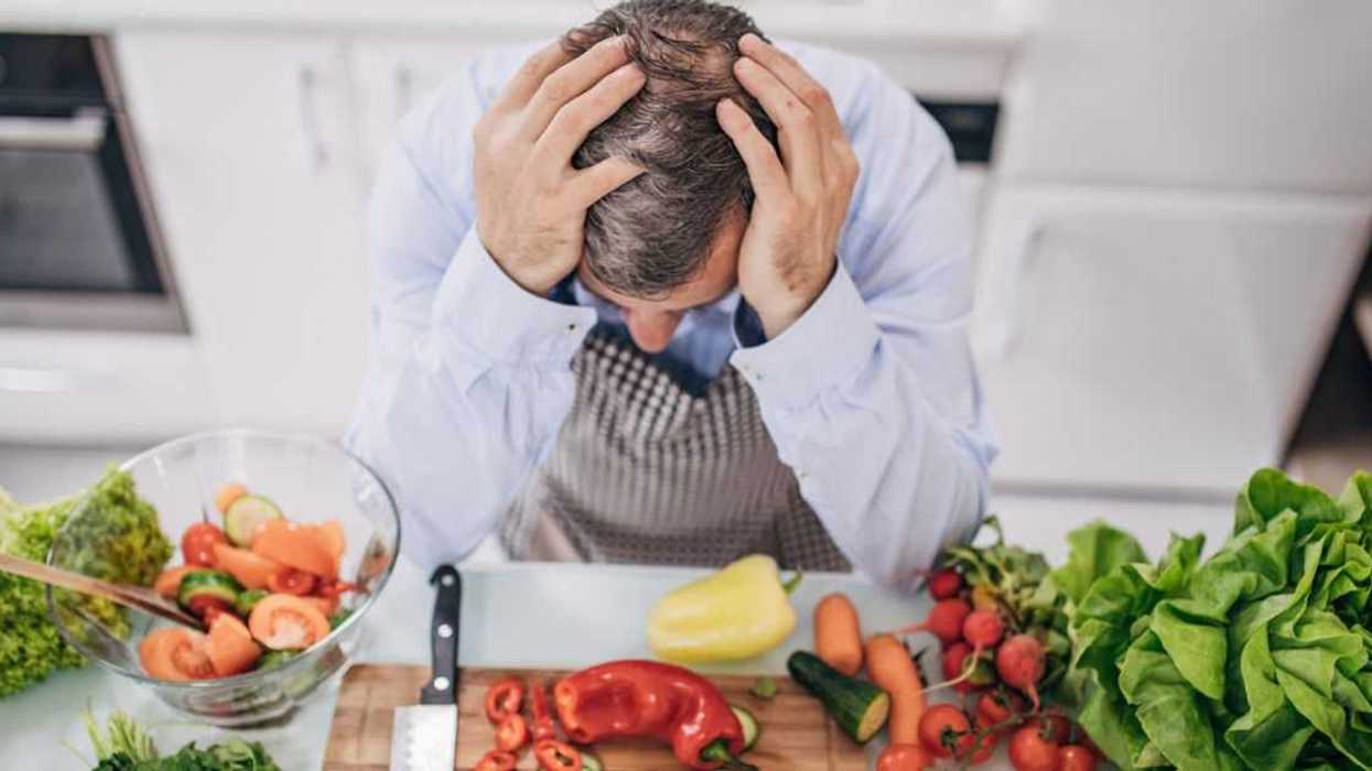 A worried old chef in the kitchen is taking a break