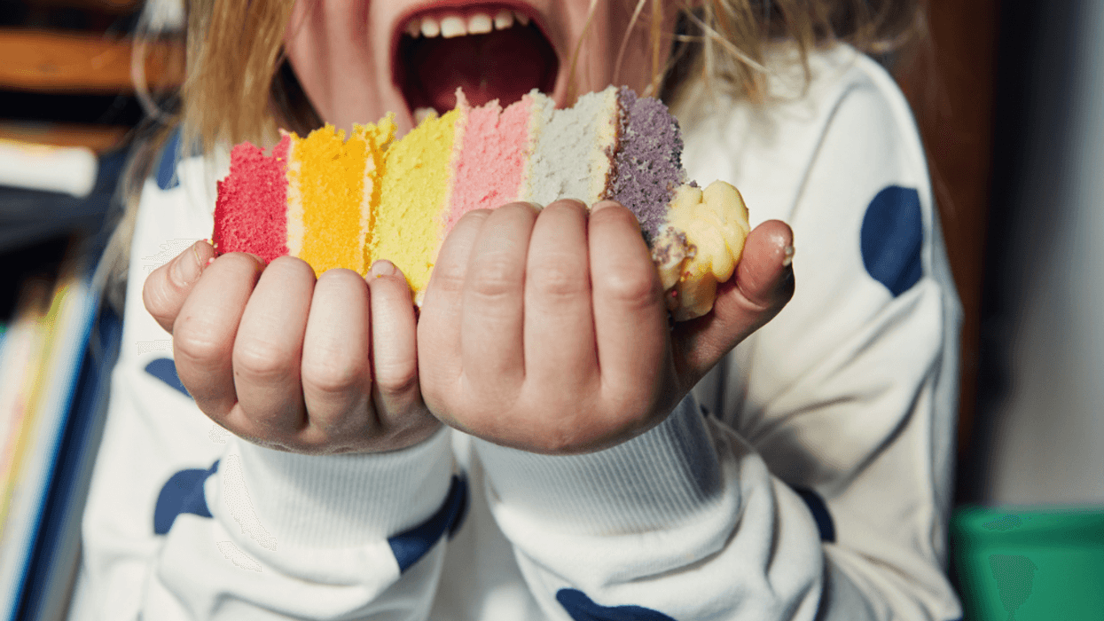 A young boy eating a large piece of cake.