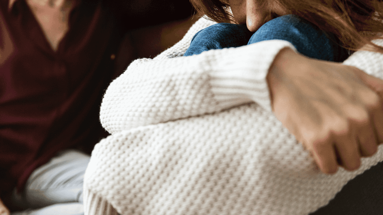 A young girl slumped over and an older woman in the background.