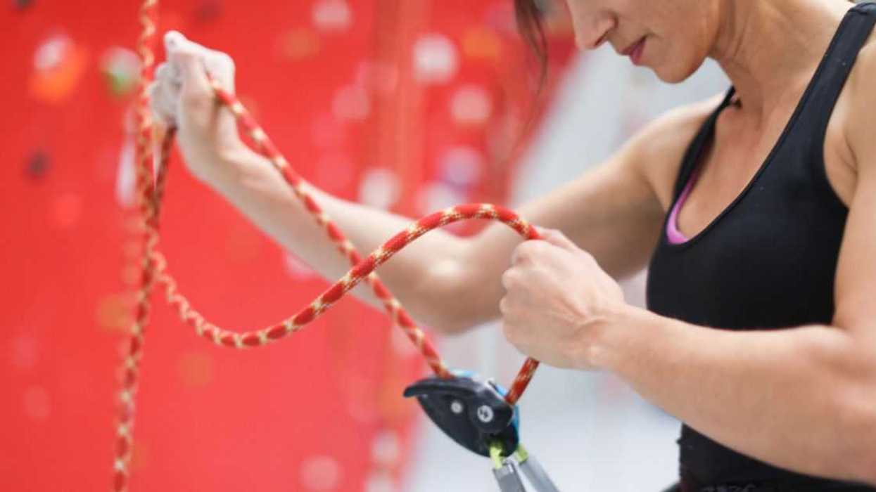 A young woman adjusts her safety harness.