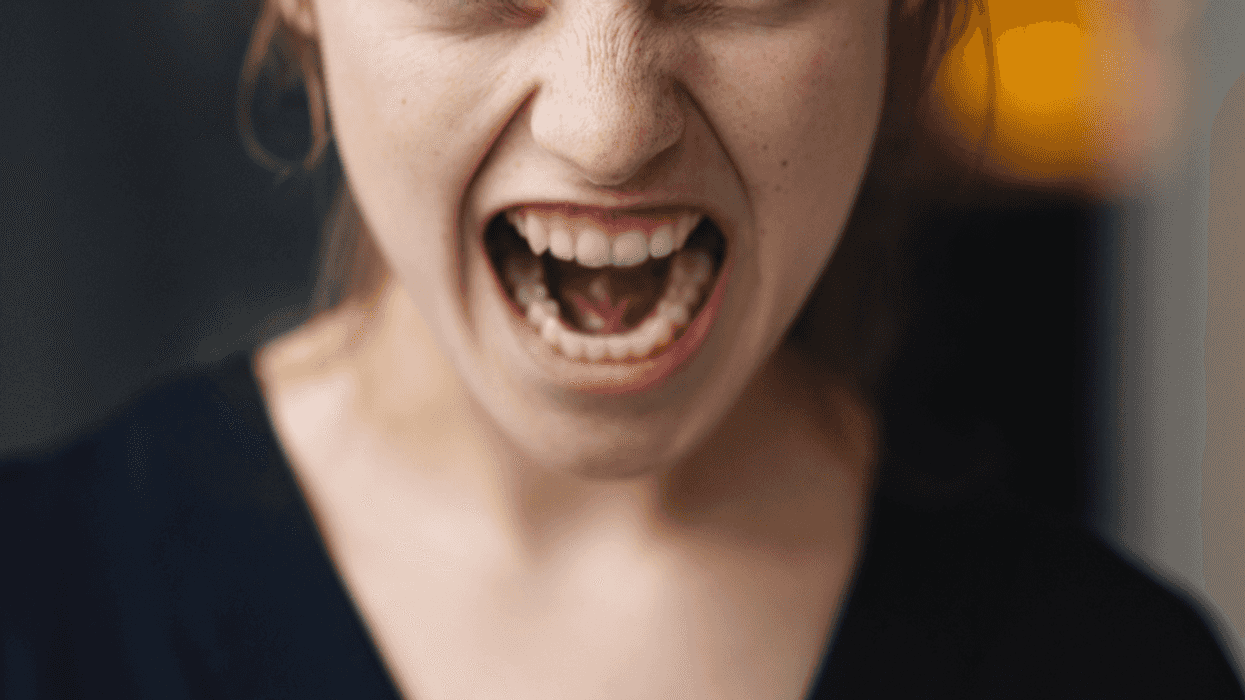 A young woman angrily screaming.