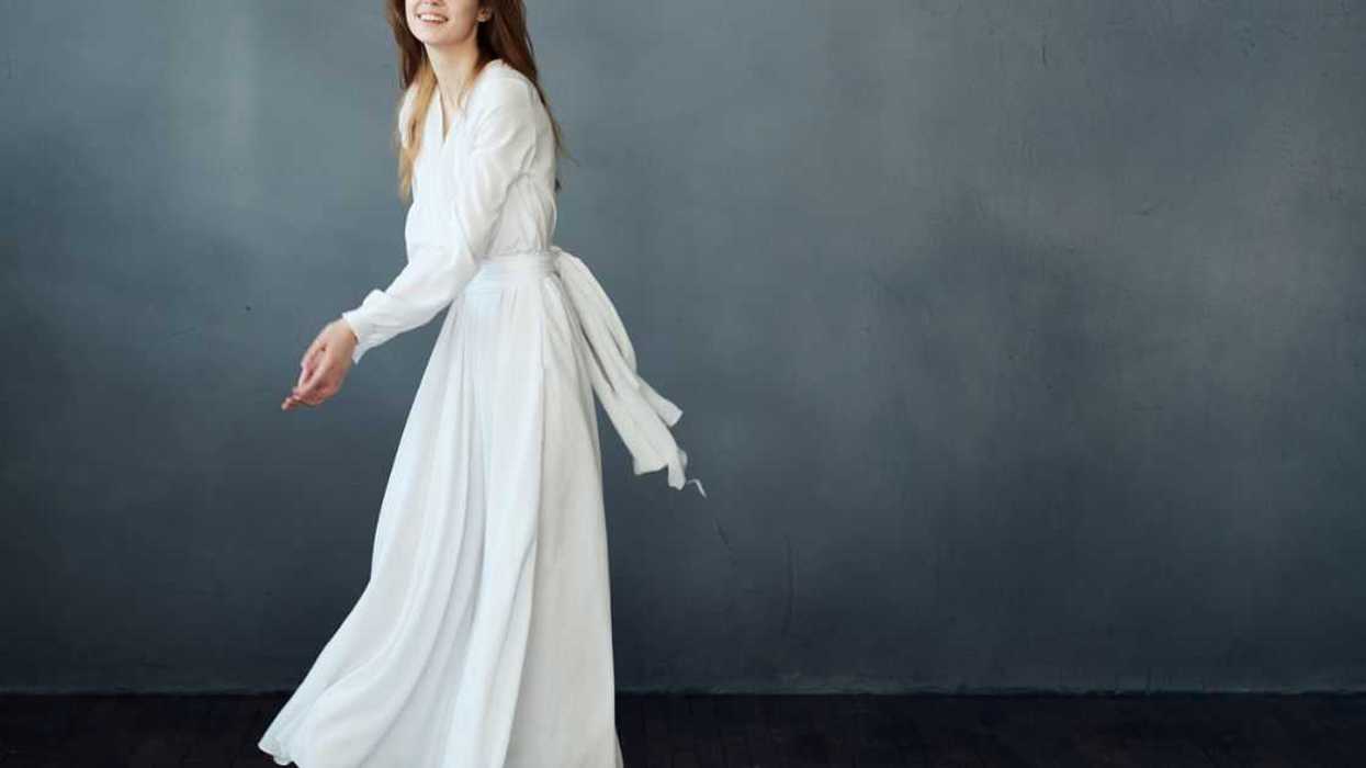 A young woman twirls in a white dress