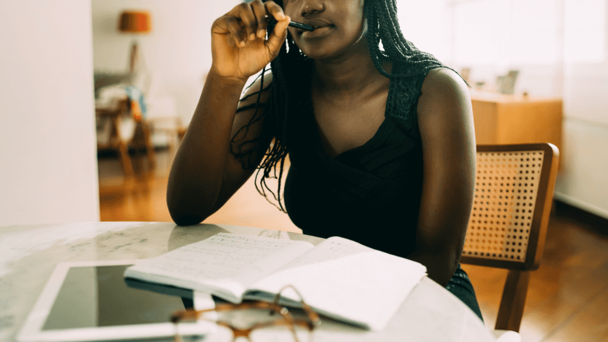 A young woman writing at her table.