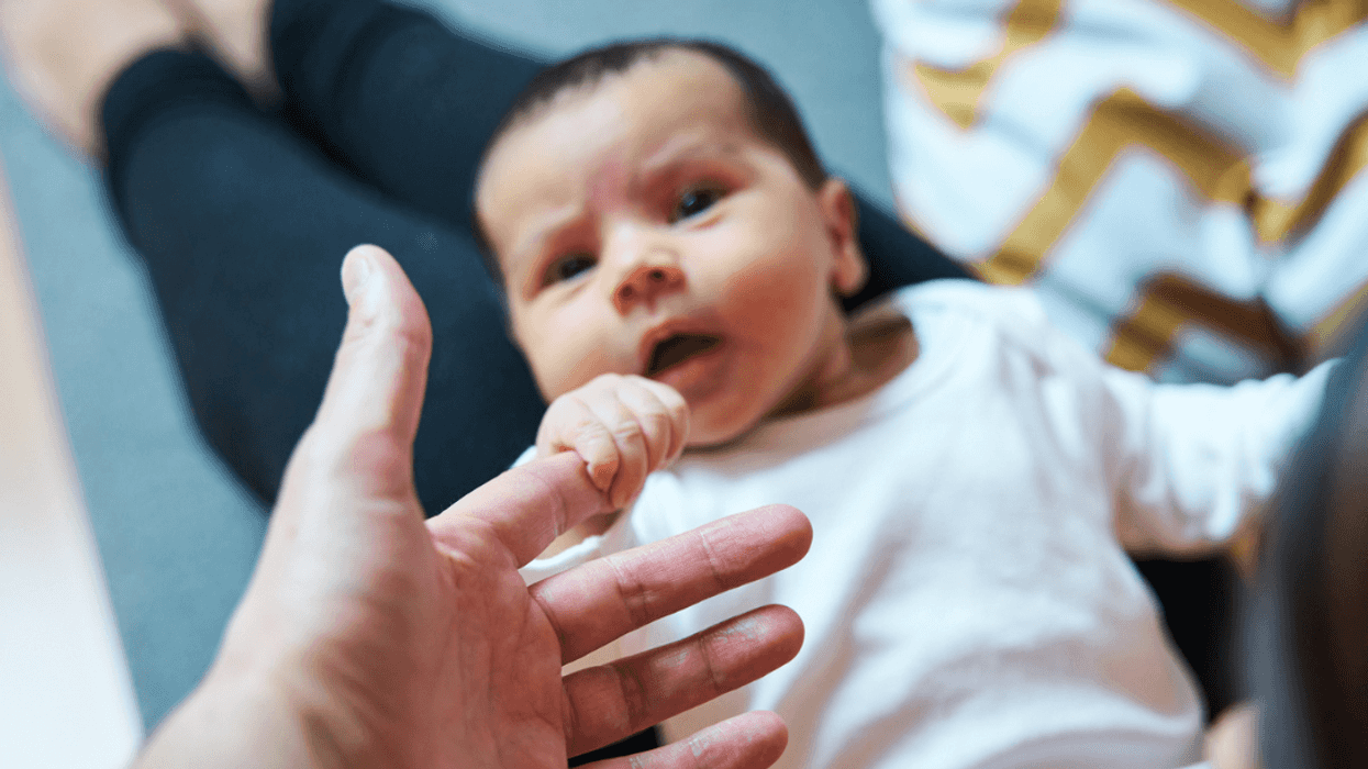 Adult holding newborn baby