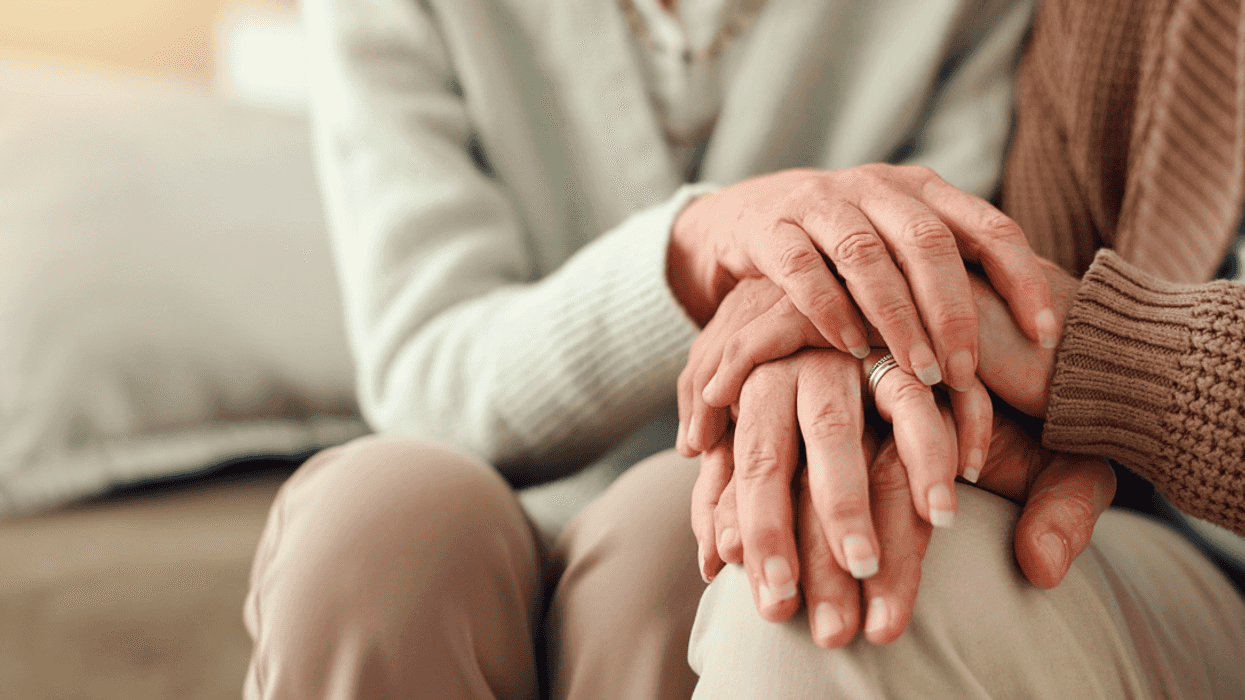 An elderly couple holding hands.