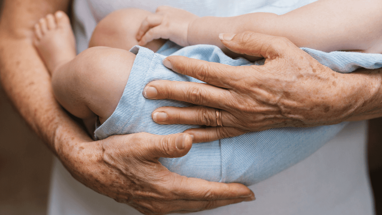 An elderly woman holding a baby.