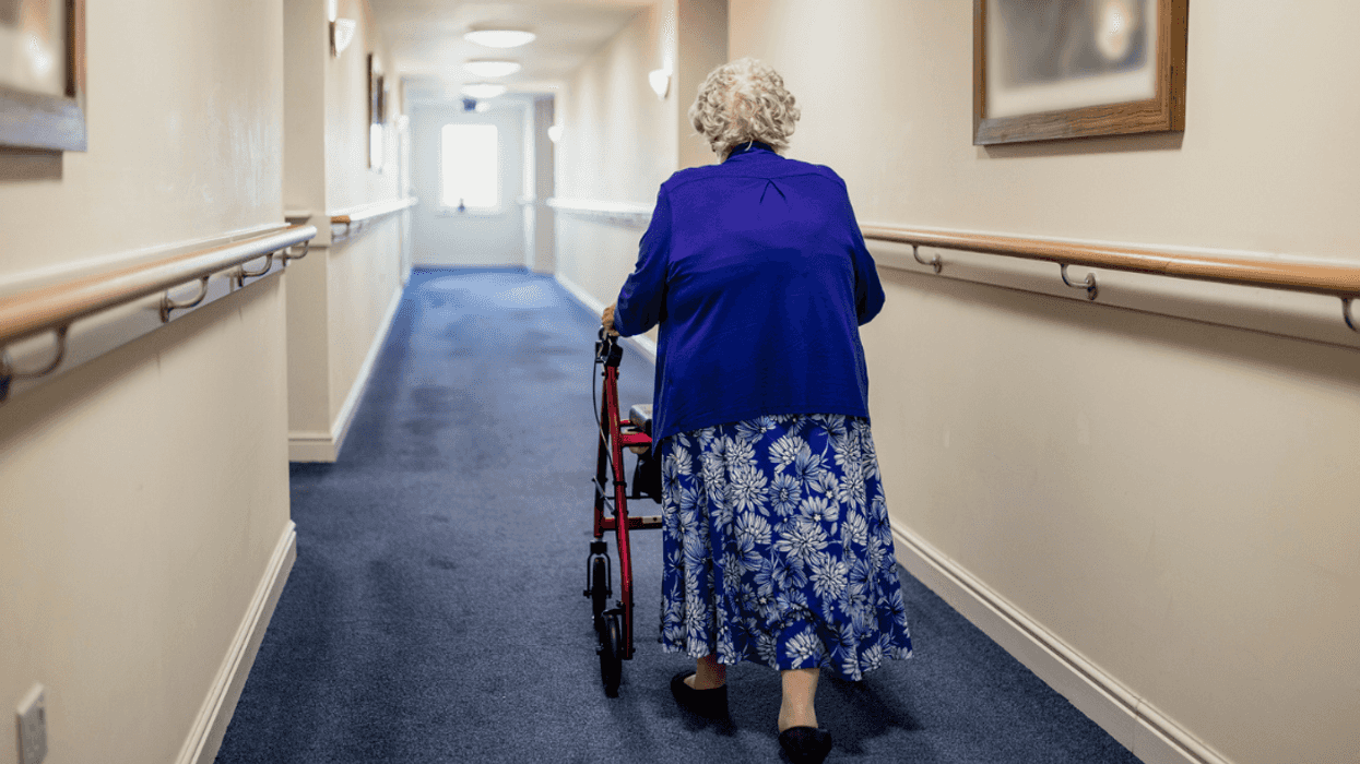 An elderly woman pushing a walker