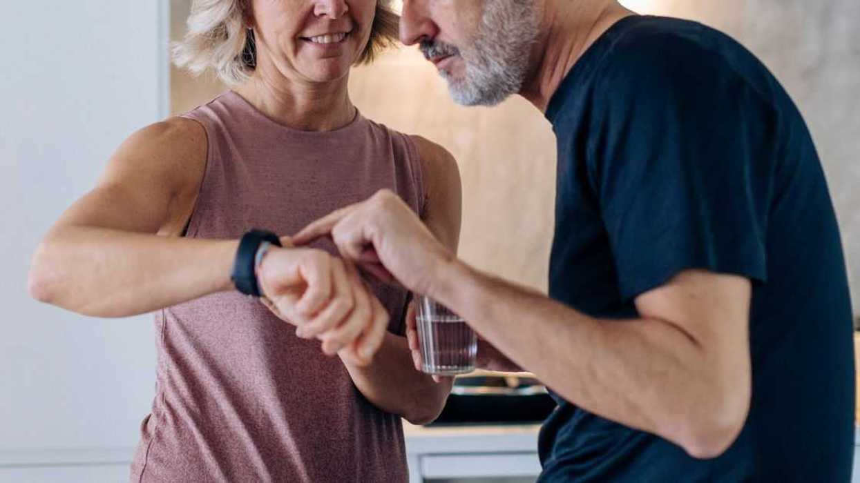 An older couple checking the time on a watch