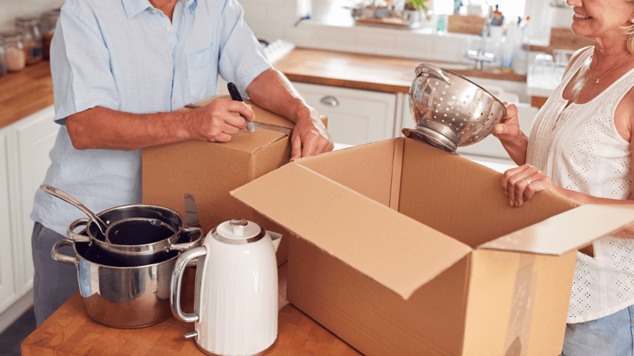 An older couple packing moving boxes.