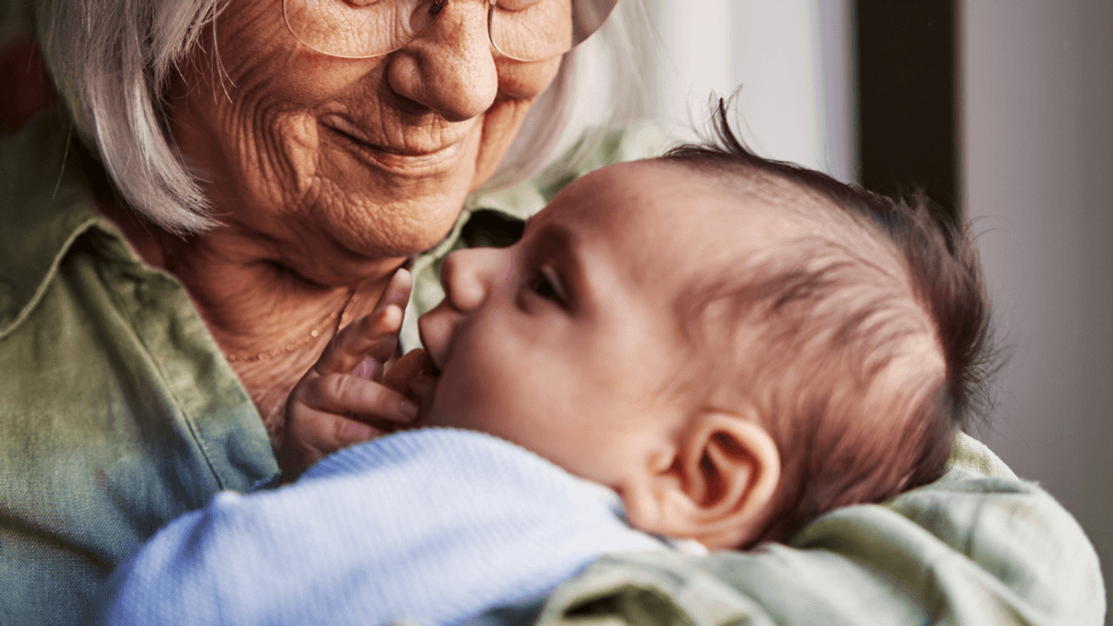 An older woman holding a baby.