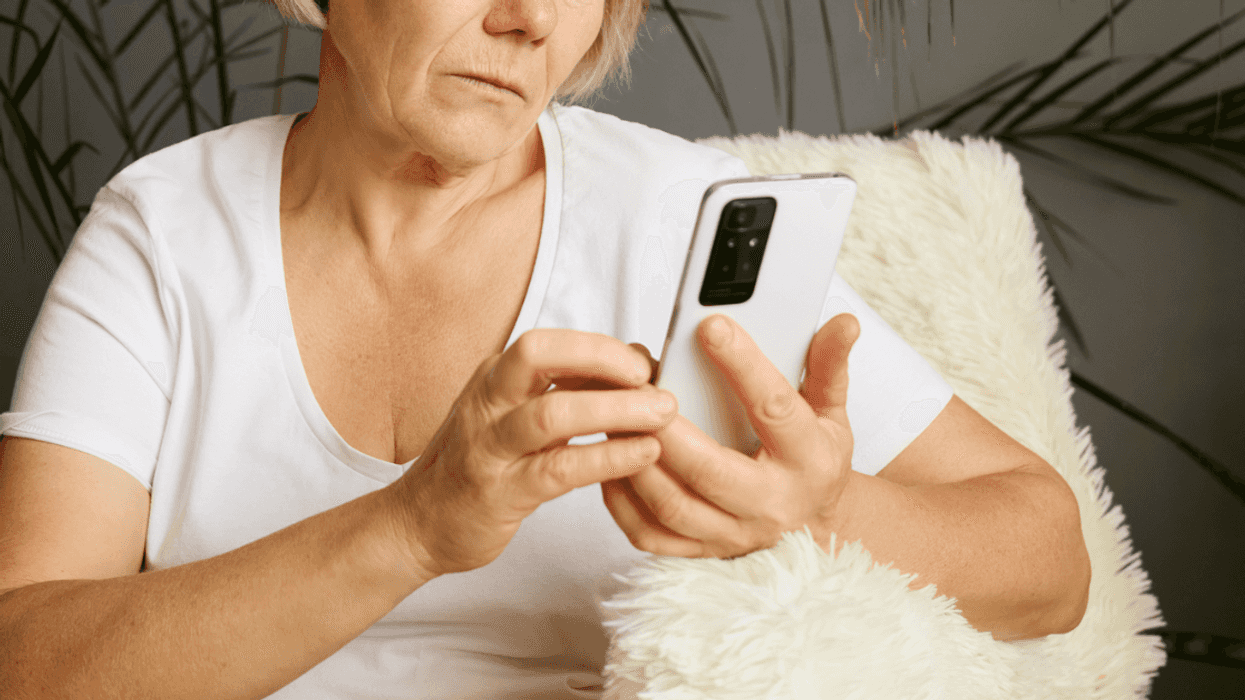 An older woman looking at a cell phone.