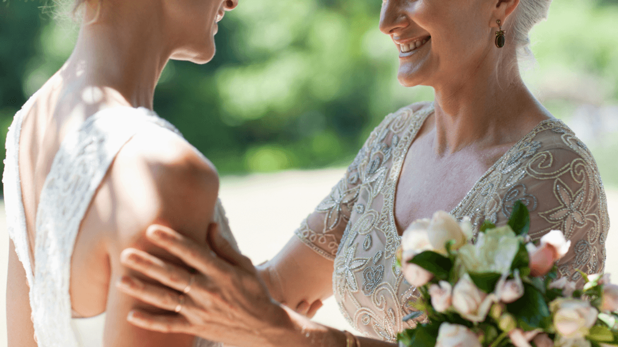 An woman with her hands on the arms of the bride.