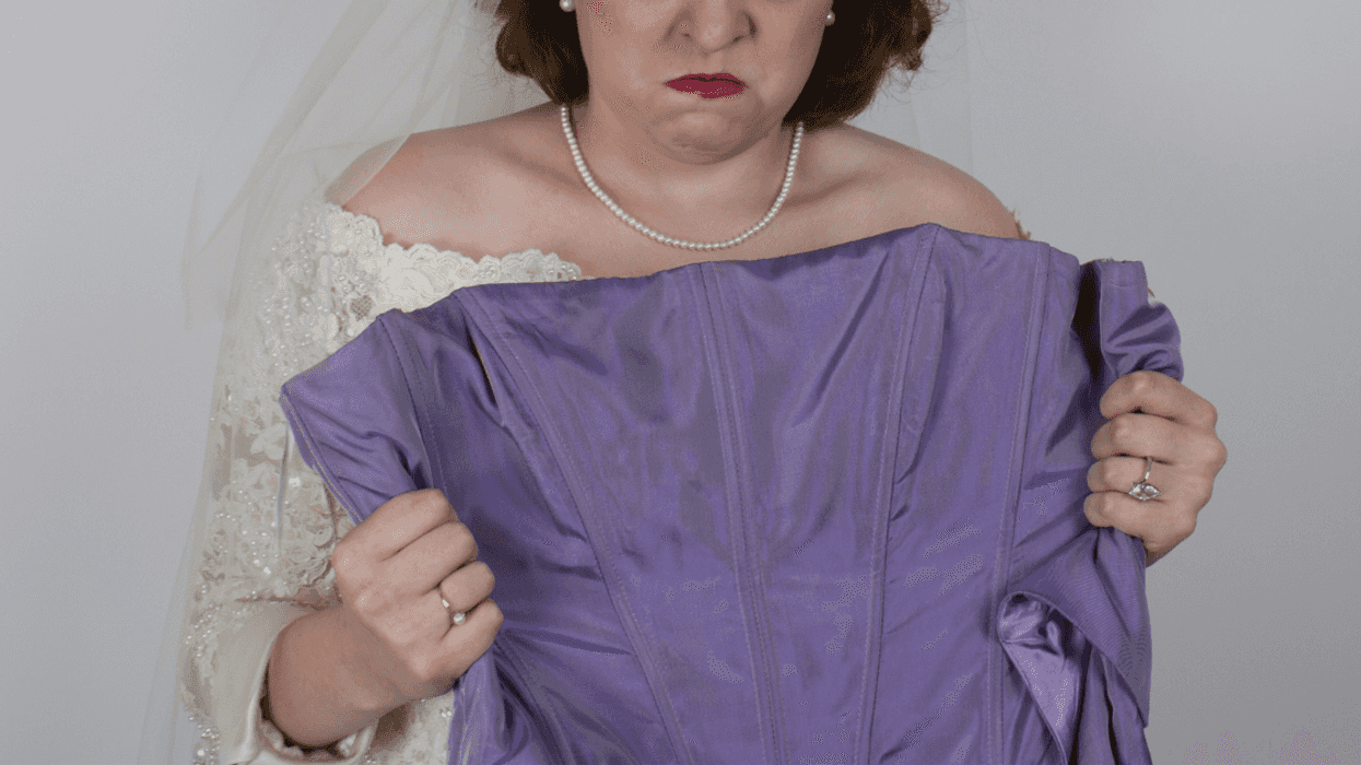 Angry bride holding up bridesmaid's dress