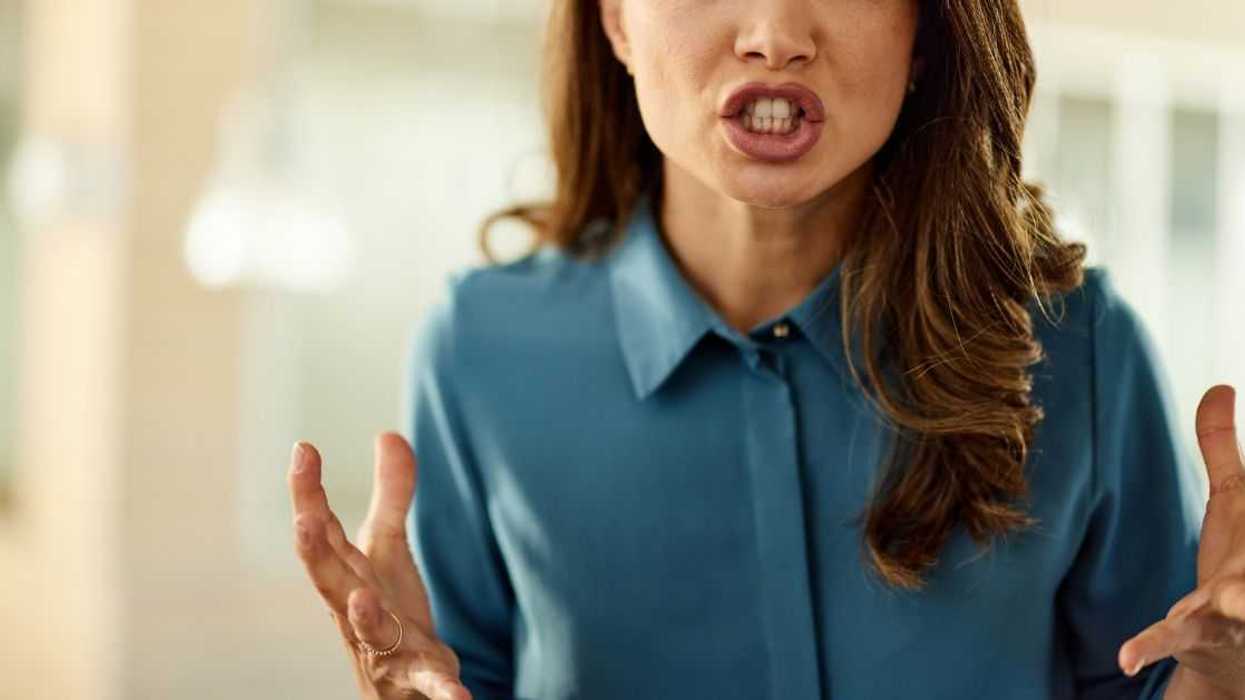 Angry female entrepreneur standing in a hallway and looking at camera.