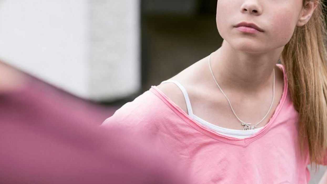 Angry girl looking at father while outdoors.